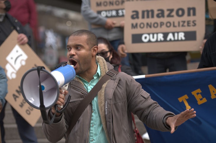 Photo of man at Amazon protest with megaphone