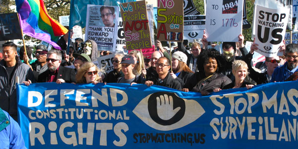 Protestors marching with a large banner and signs